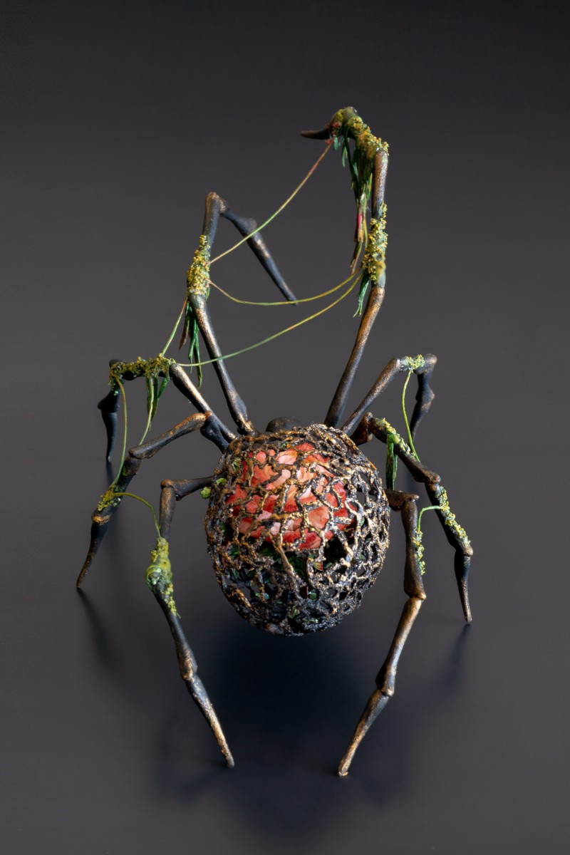 Black spider sculpture with a rose