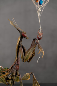 Sculpture of a mantis with a spider  "On a Thin Threa"
